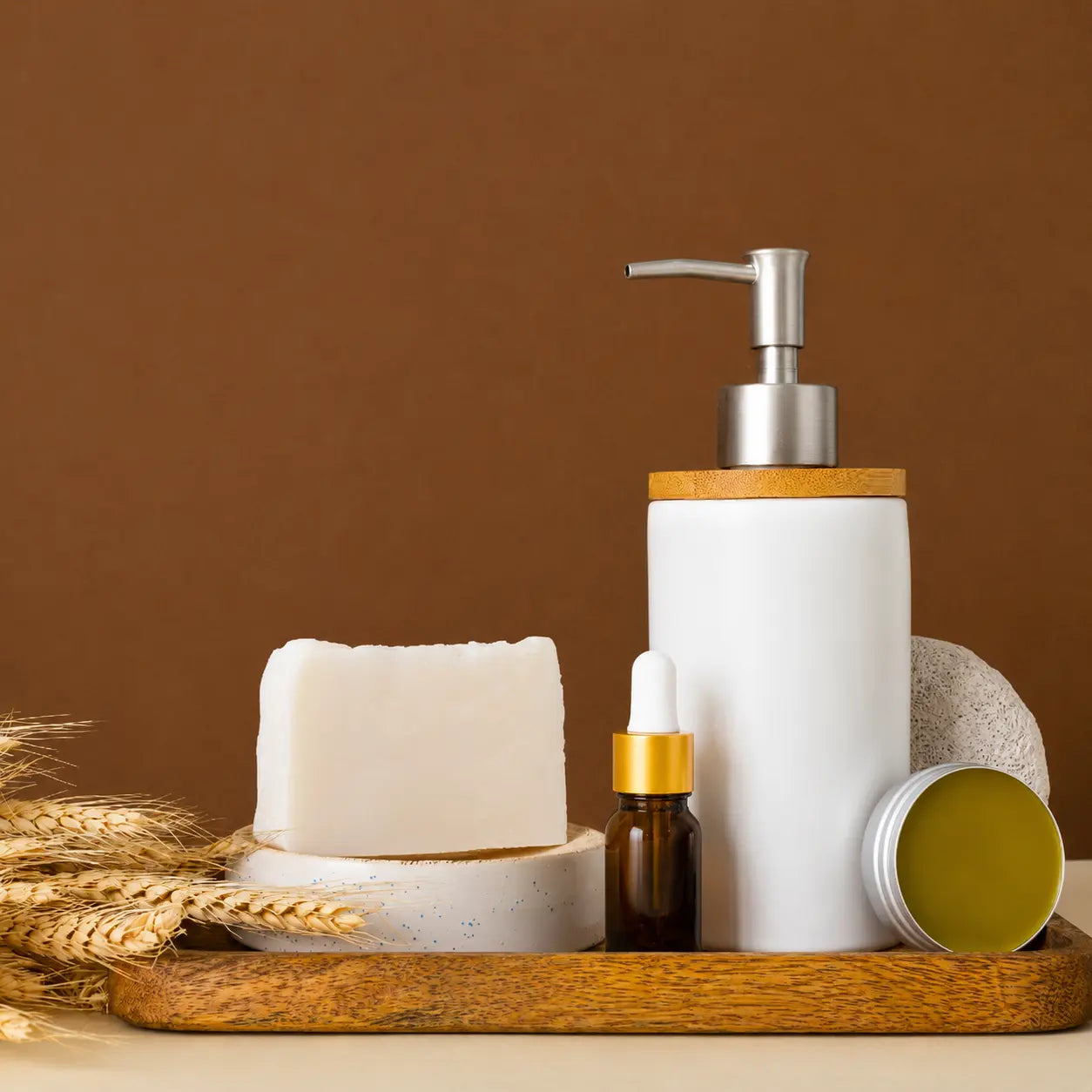 Natural Ayurvedic skincare products including handmade soap, herbal balm, serum, and lotion bottle arranged on a wooden tray